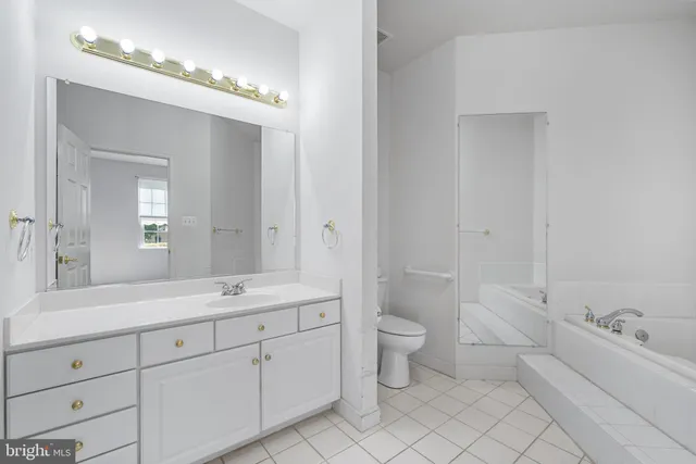 a spacious bathroom with a double vanity sink mirror and toilet