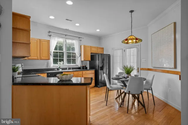 a kitchen that has a table chairs in it and wooden floors