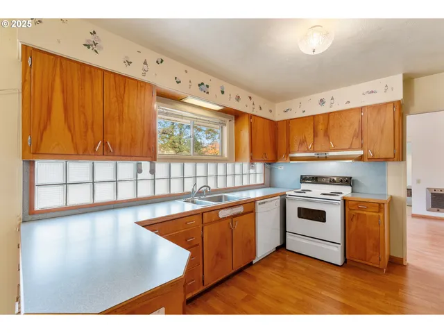 a kitchen with stainless steel appliances granite countertop a sink dishwasher and cabinets with wooden floor