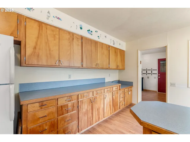 a kitchen with cabinets and wooden floor