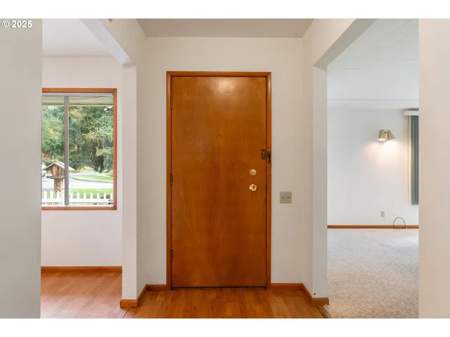 a view of an empty room with a fireplace and a window