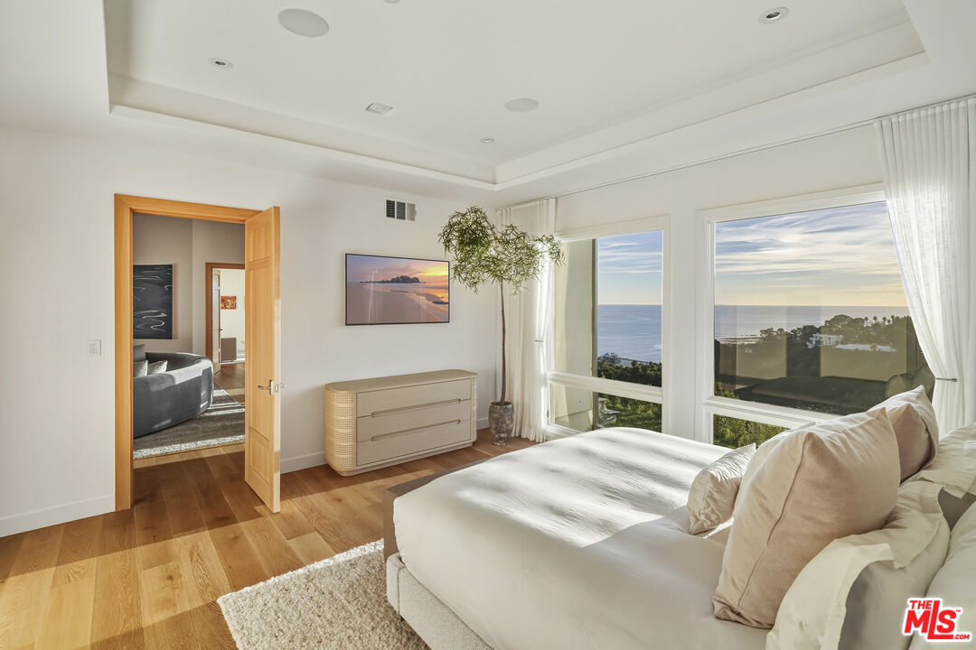 3140 Sweetwater Mesa Road Malibu, CA 90265 - Photo 24 of 71 a bedroom with a bed and glass window