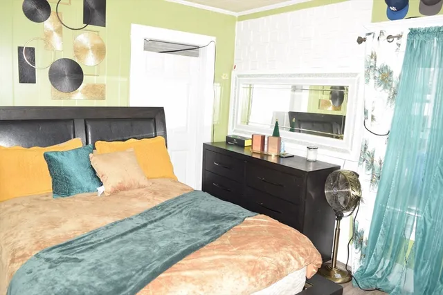 a bedroom with a bed and a refrigerator