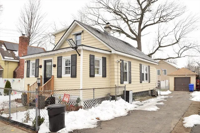 a front view of a house with a yard covered in snow