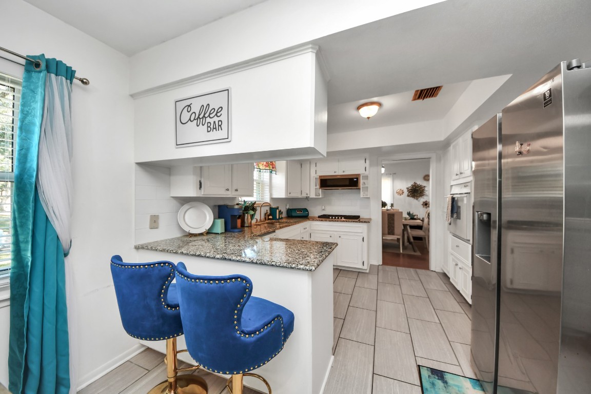 1805 9th Street Hempstead, TX 77445 - Photo 11 of 35 a kitchen with stainless steel appliances granite countertop a refrigerator and a stove top oven