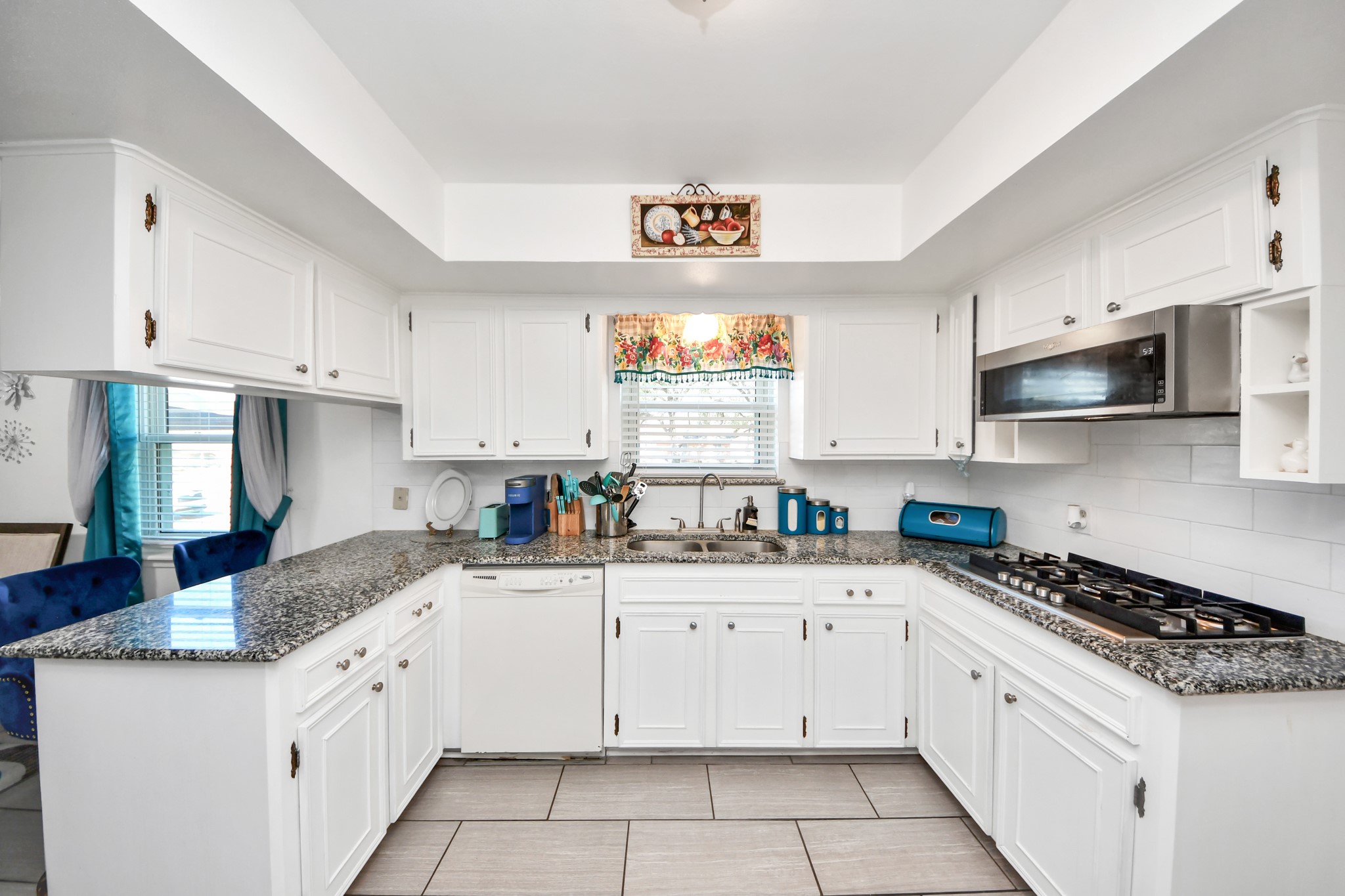 1805 9th Street Hempstead, TX 77445 - Photo 12 of 35 a kitchen with granite countertop a sink a stove a microwave and wooden cabinets