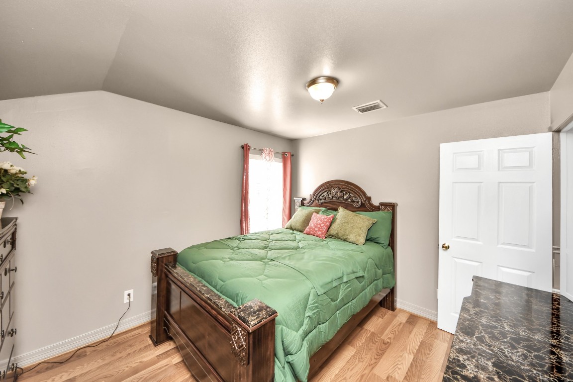 1805 9th Street Hempstead, TX 77445 - Photo 19 of 35 a bedroom with a bed and wooden floor