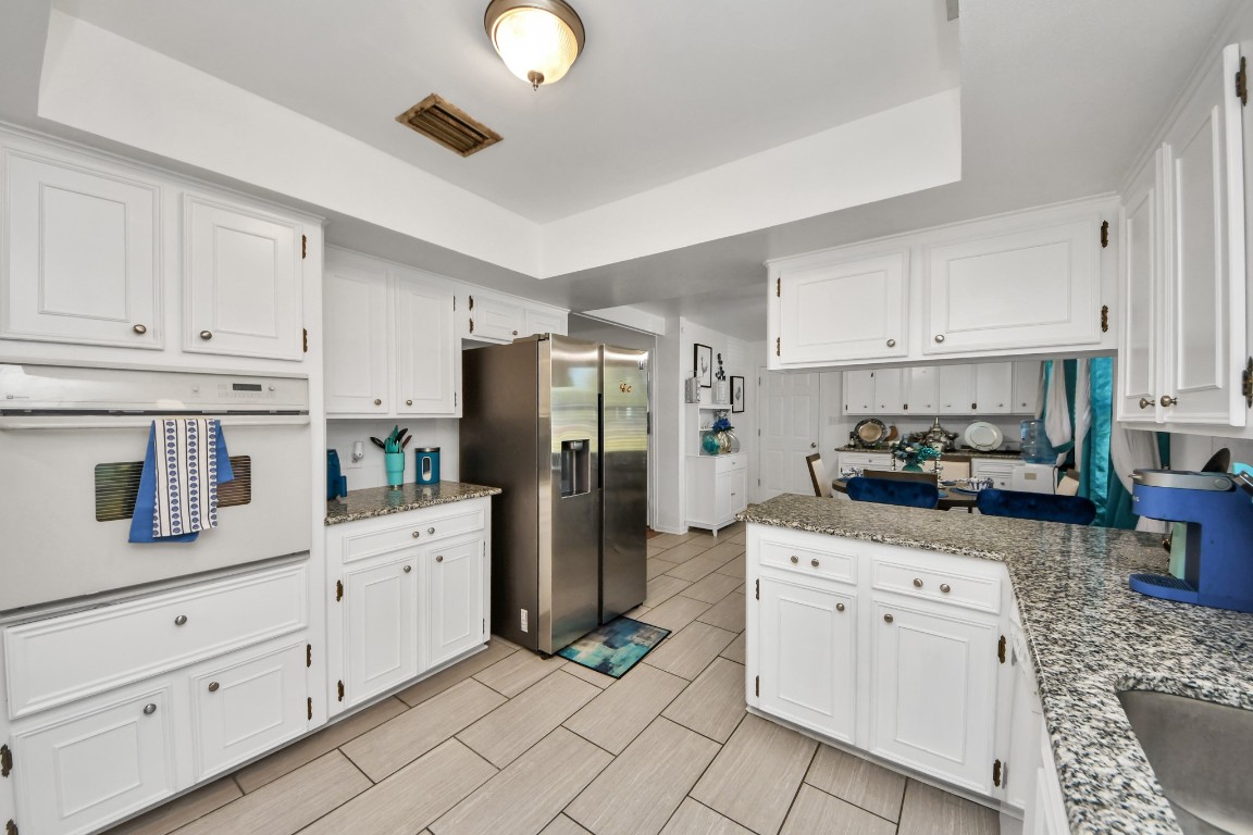 1805 9th Street Hempstead, TX 77445 - Photo 9 of 35 a kitchen with white cabinets and stainless steel appliances