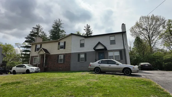 a car parked in front of a house with a white bed