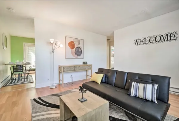 a living room with furniture and wooden floor