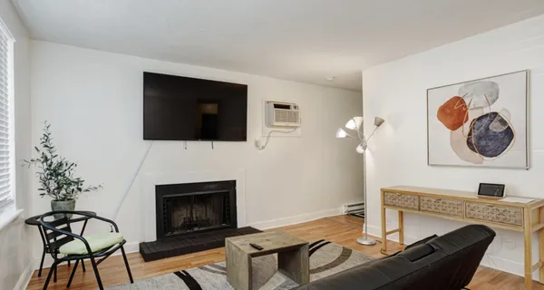 a living room with furniture a fireplace and a flat screen tv
