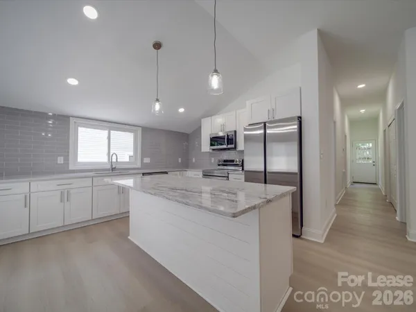 a view of a kitchen with a sink and refrigerator