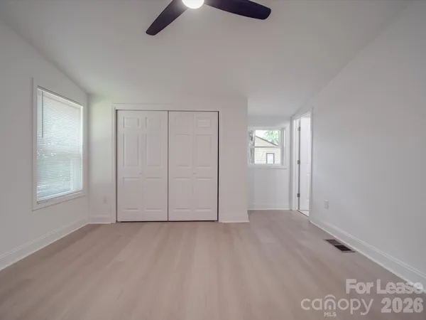 an empty room with windows and closet