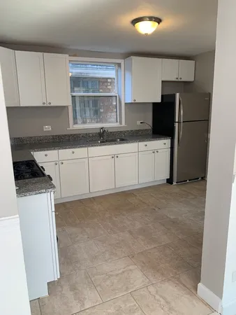 a kitchen with granite countertop a refrigerator stove top oven a sink and dishwasher