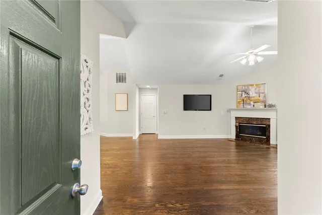 a view of an empty room with a window and wooden floor