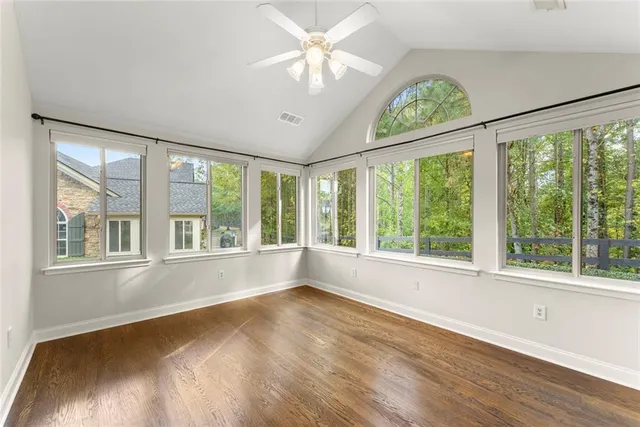 a view of an empty room with window fireplace and wooden floor