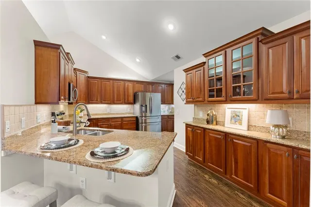 a kitchen with granite countertop a sink stove and refrigerator