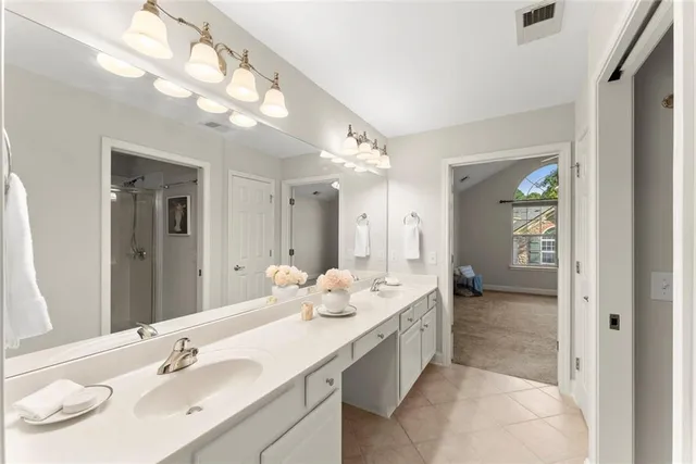 an empty room with a window and chandelier fan