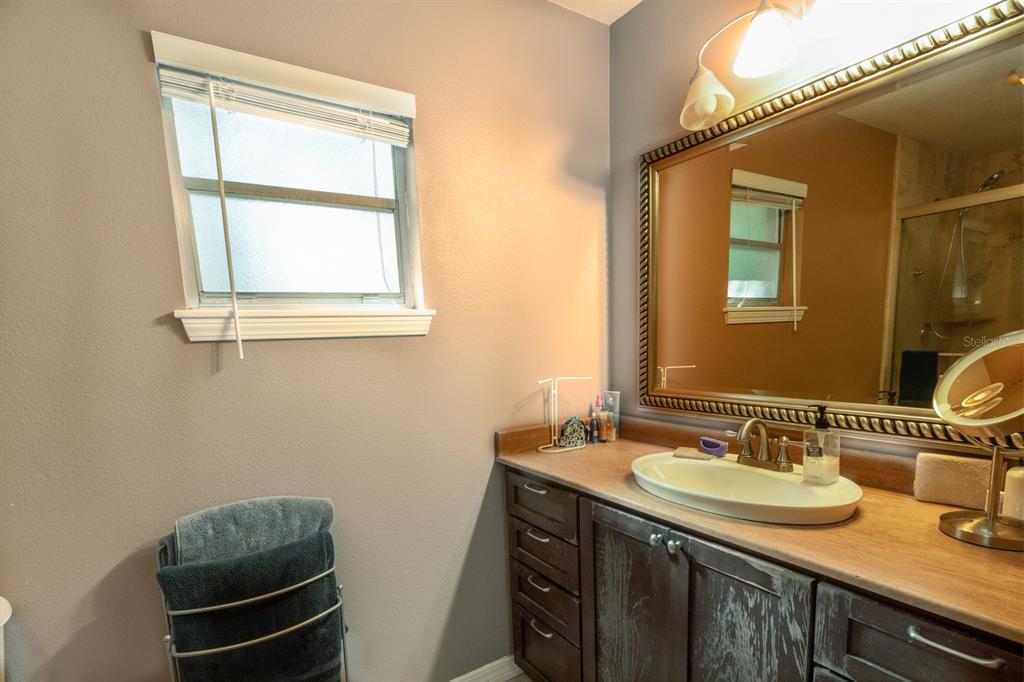 560 North Lake Pleasant Road Apopka, FL 32712 - Photo 12 of 85 a bathroom with a granite countertop sink a mirror and a window