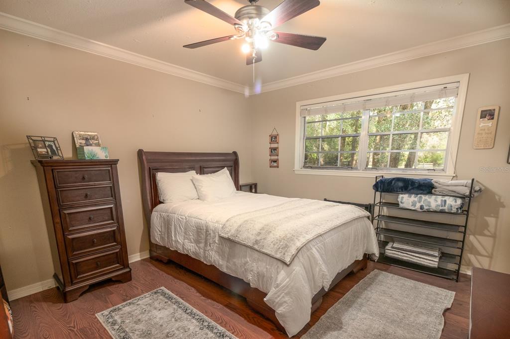 560 North Lake Pleasant Road Apopka, FL 32712 - Photo 15 of 85 a bedroom with a bed and a chandelier
