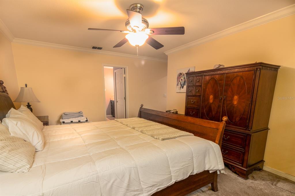 560 North Lake Pleasant Road Apopka, FL 32712 - Photo 10 of 85 a bedroom with a bed and a chandelier