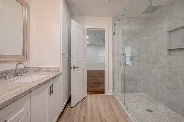 a bathroom with a granite countertop sink mirror and shower