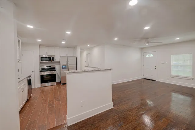 a view of a kitchen with a sink and dishwasher a refrigerator with wooden floor