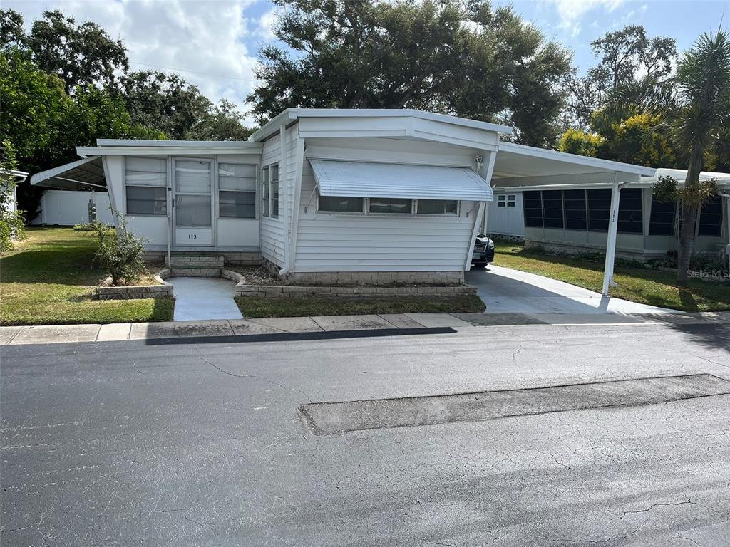 1040 Main Street, Unit 193 Dunedin, FL 34698 - Photo 2 of 16 a view of house with outdoor space and parking