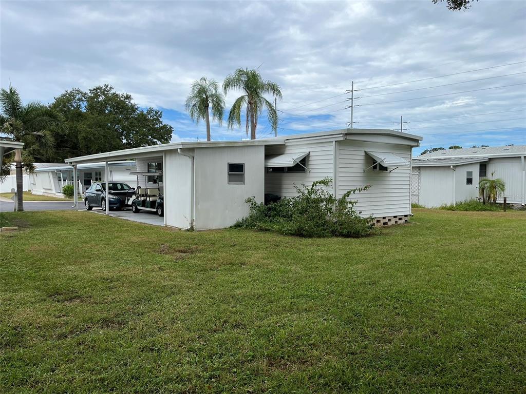 1040 Main Street, Unit 193 Dunedin, FL 34698 - Photo 4 of 16 a front view of house with yard and trees