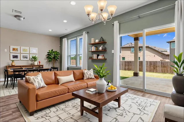 a living room with furniture a table and a chandelier