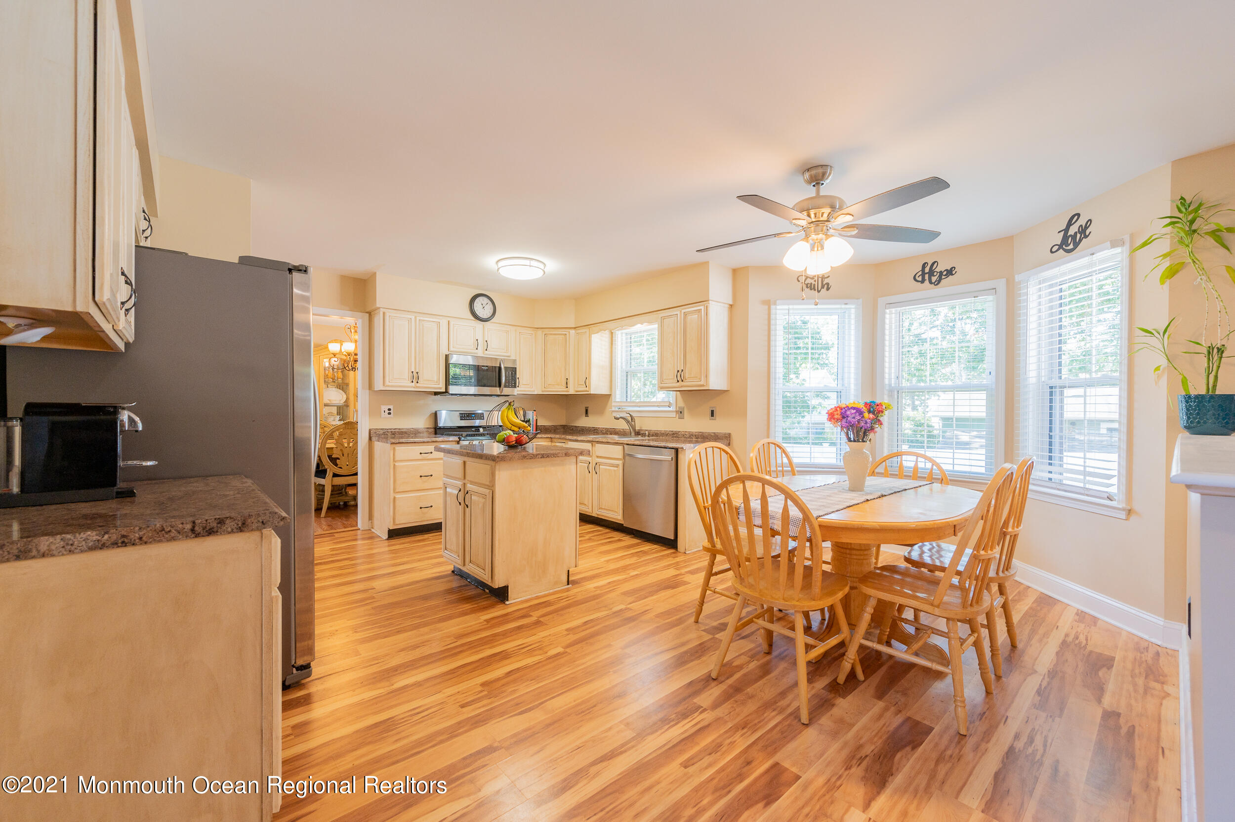 121 Lanyard Road Manahawkin, NJ 08050 - Photo 14 of 39 a dining hall with stainless steel appliances a dining table wooden floor and a view of kitchen
