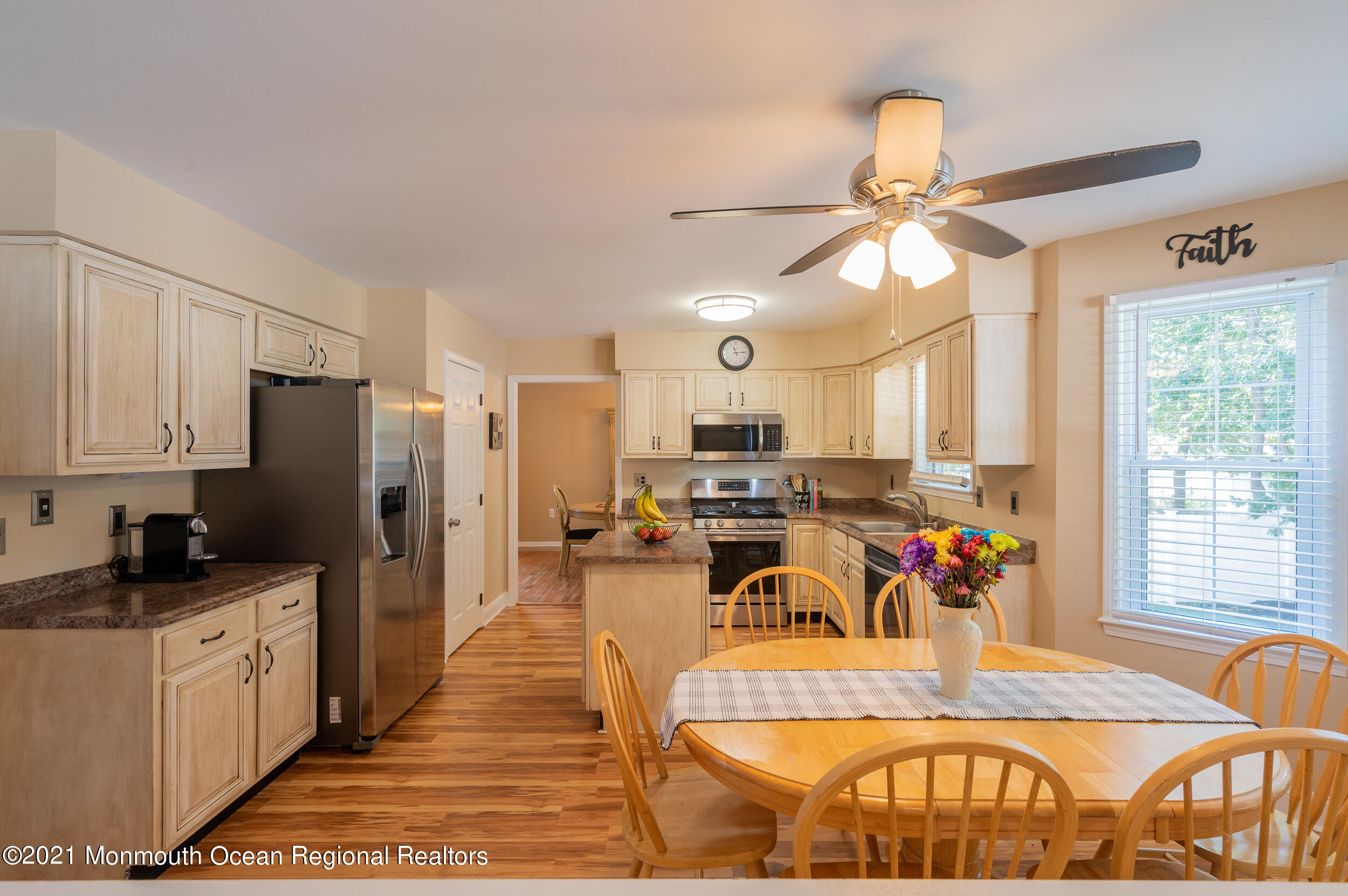 121 Lanyard Road Manahawkin, NJ 08050 - Photo 17 of 39 a view of a kitchen with kitchen island granite countertop a refrigerator a stove a dining table and chairs with wooden floor