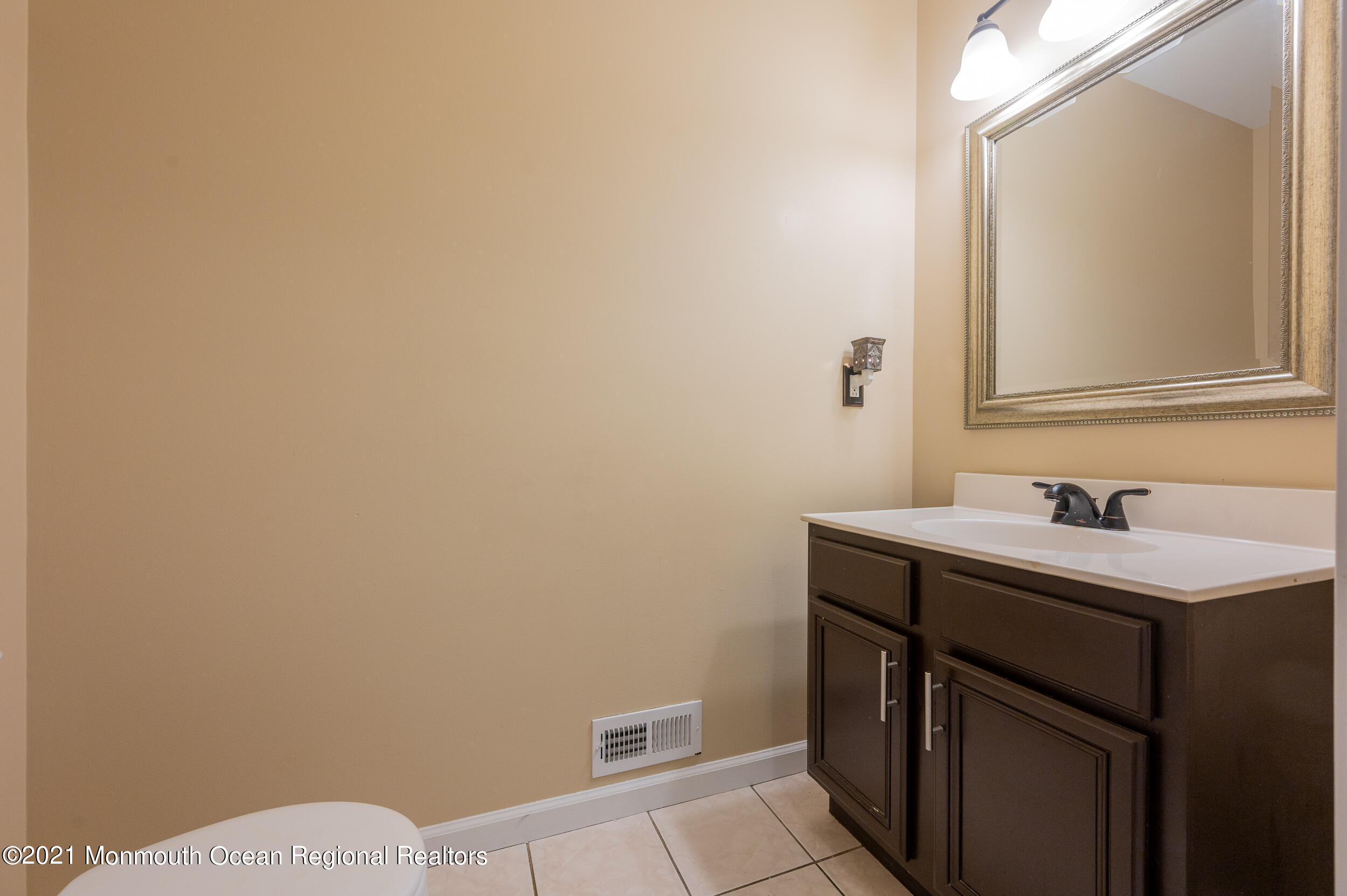 121 Lanyard Road Manahawkin, NJ 08050 - Photo 22 of 39 a bathroom with a sink a toilet and mirror