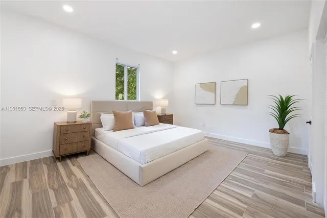 a bedroom with a large bed and a potted plant