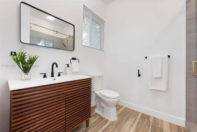 a bathroom with a sink toilet and mirror