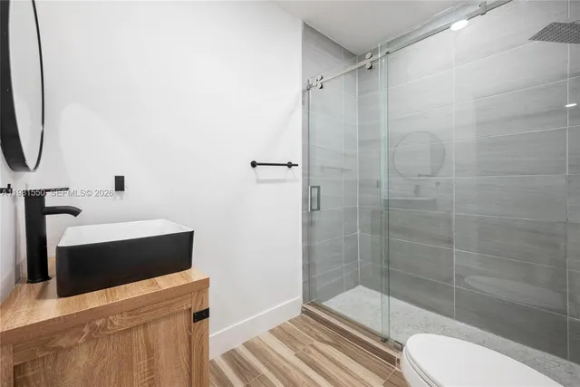 a bathroom with a shower a toilet and sink