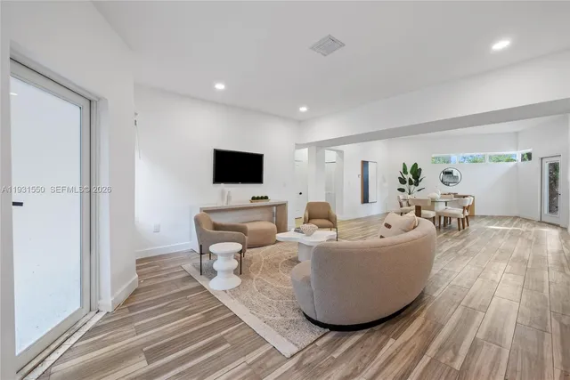 a living room with furniture and a wooden floor