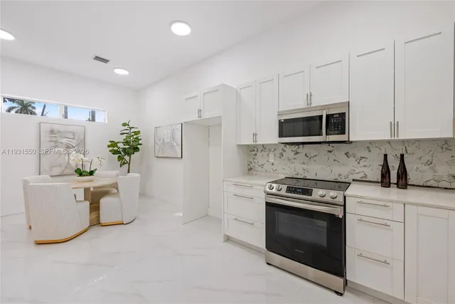 a kitchen with white cabinets and white appliances