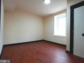 5013 Chester Avenue, Unit 1 Philadelphia, PA 19143 - Photo 11 of 12 an empty room with wooden floor and windows