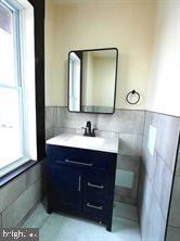5013 Chester Avenue, Unit 1 Philadelphia, PA 19143 - Photo 12 of 12 a bathroom with a sink vanity and mirror