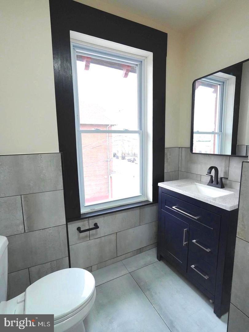 5013 Chester Avenue, Unit 1 Philadelphia, PA 19143 - Photo 6 of 12 a bathroom with a sink vanity mirror and toilet