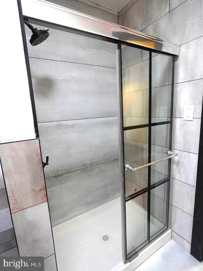 5013 Chester Avenue, Unit 1 Philadelphia, PA 19143 - Photo 7 of 12 a bathroom with a glass shower door