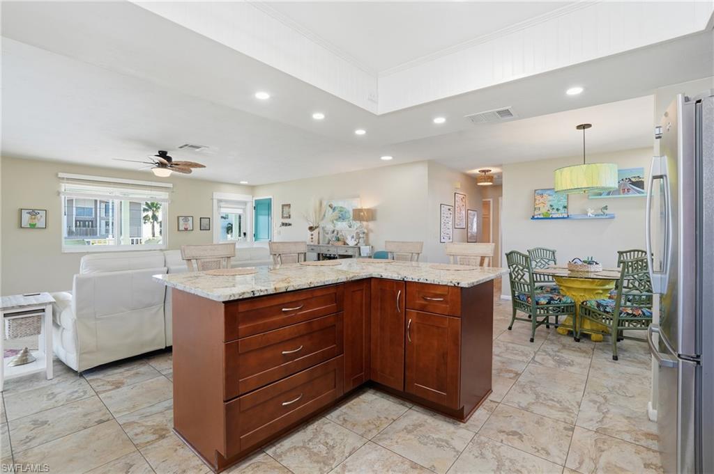 170 Redfish Road Fort Myers Beach, FL 33931 - Photo 12 of 48 a kitchen with granite countertop a sink and a refrigerator