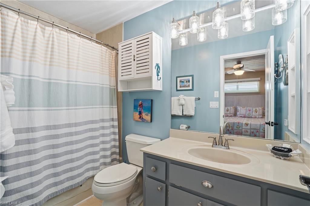 170 Redfish Road Fort Myers Beach, FL 33931 - Photo 23 of 48 a bathroom with a sink a toilet and shower curtain