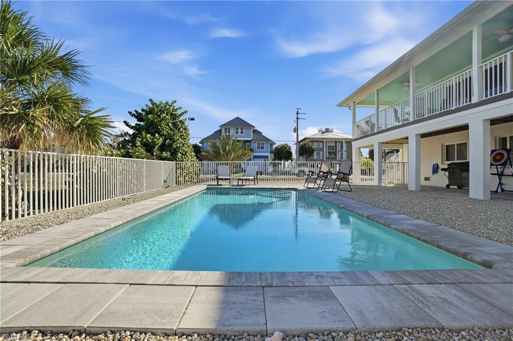 170 Redfish Road Fort Myers Beach, FL 33931 - Photo 30 of 48 a view of a swimming pool with a lounge chairs