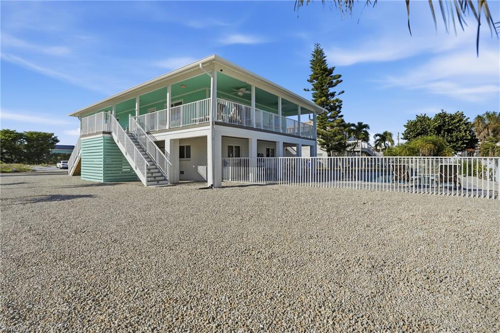 170 Redfish Road Fort Myers Beach, FL 33931 - Photo 3 of 48 a front view of a house with a garden