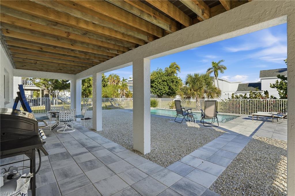 170 Redfish Road Fort Myers Beach, FL 33931 - Photo 33 of 48 a view of a patio with table and chairs potted plants with wooden floor and fence