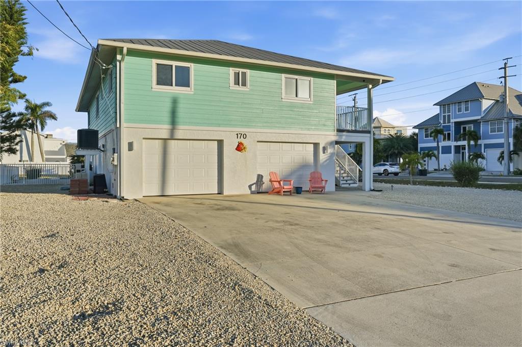 170 Redfish Road Fort Myers Beach, FL 33931 - Photo 4 of 48 a front view of a house with a garage