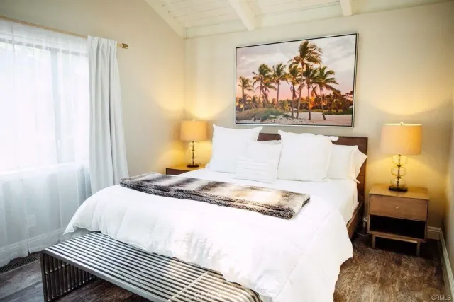 a bedroom with a bed and a painting on the wall