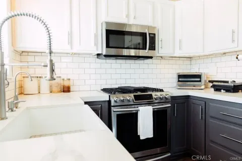 a kitchen with stainless steel appliances a stove a microwave sink and cabinets